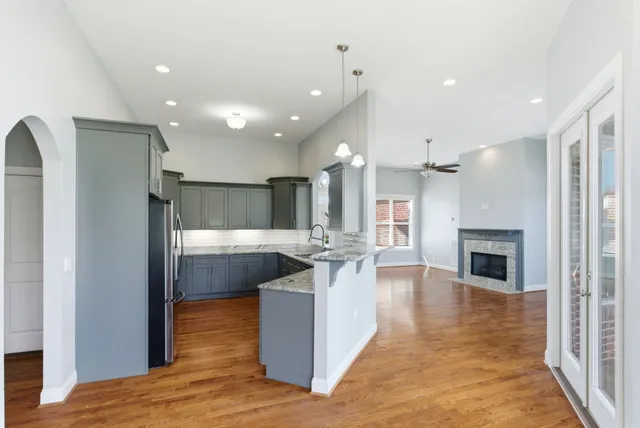 a kitchen with stainless steel appliances granite countertop a sink refrigerator and cabinets