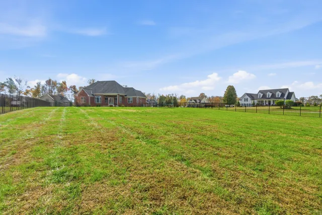 a front view of a house with a garden and trees