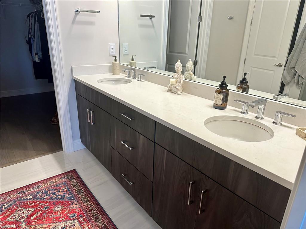 9179 Cayman Drive Naples, FL 34114 - Photo 20 of 50 a bathroom with a double vanity sink and a mirror