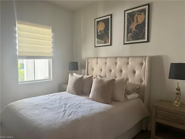 a large bed sitting in a bedroom next to a window