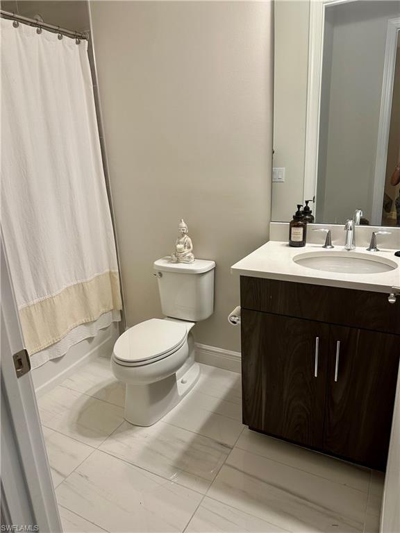 9179 Cayman Drive Naples, FL 34114 - Photo 31 of 50 a bathroom with a toilet sink and mirror
