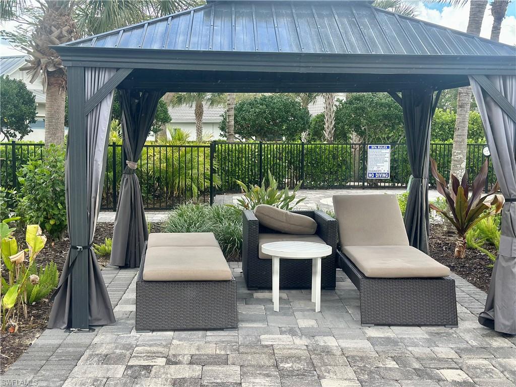 9179 Cayman Drive Naples, FL 34114 - Photo 40 of 50 a view of a patio with table and chairs potted plants with wooden floor