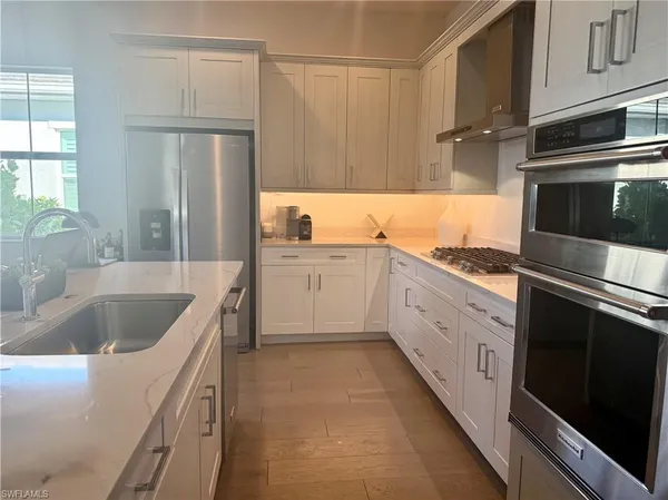 a kitchen with a sink stove top oven and cabinets