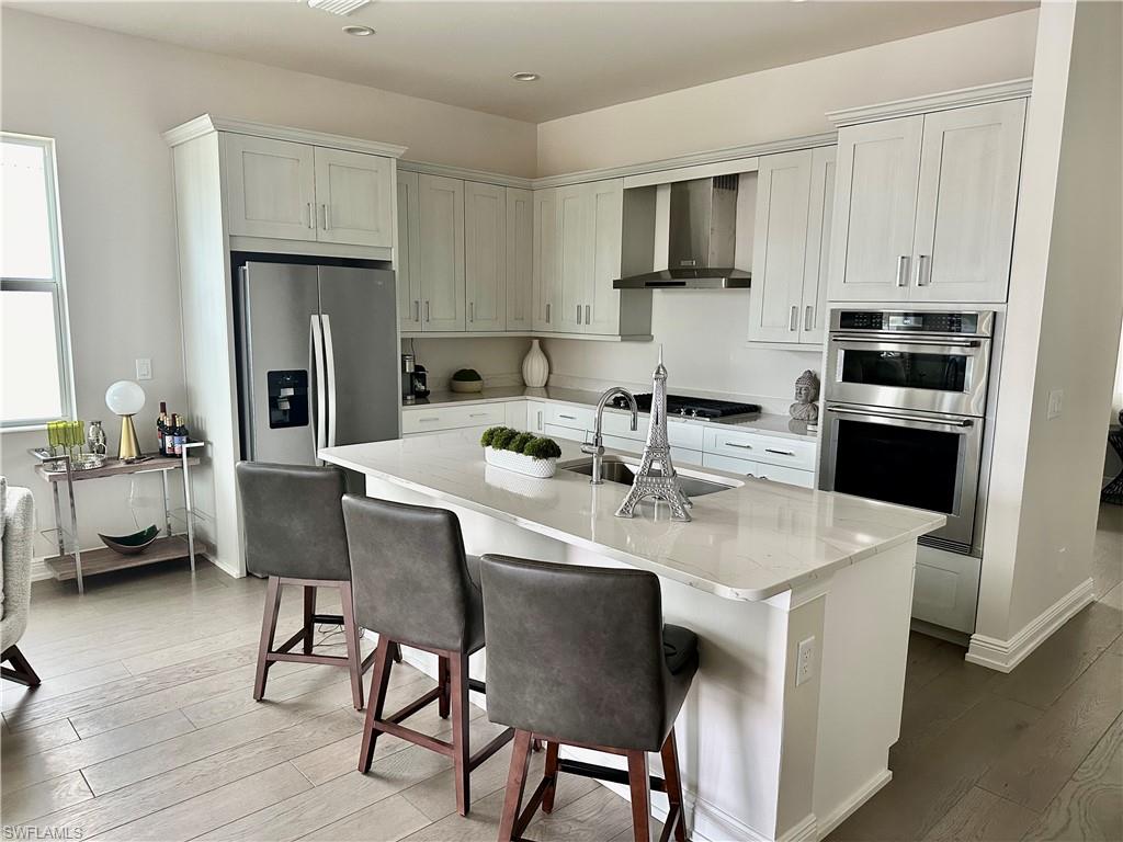9179 Cayman Drive Naples, FL 34114 - Photo 8 of 50 a kitchen with stainless steel appliances granite countertop a table chairs microwave and sink