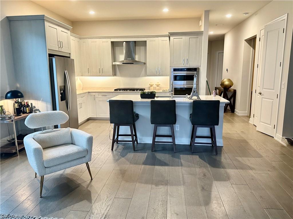 9179 Cayman Drive Naples, FL 34114 - Photo 10 of 50 a kitchen with stainless steel appliances kitchen island granite countertop a table and chairs