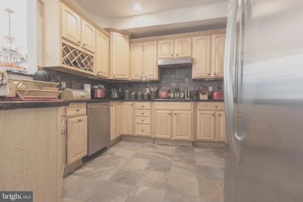 a kitchen with white cabinets and sink