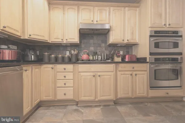 a kitchen with granite countertop white cabinets and stainless steel appliances