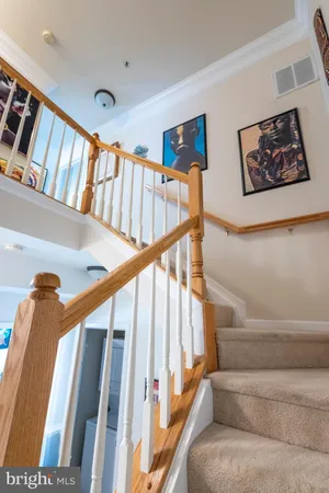 a view of staircase with lots of frames on wall and a window
