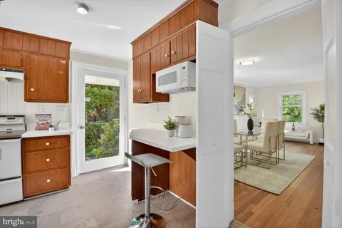 a view of kitchen island dining room wooden floor and living room