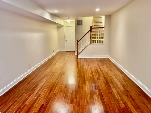 a view of empty room with wooden floor