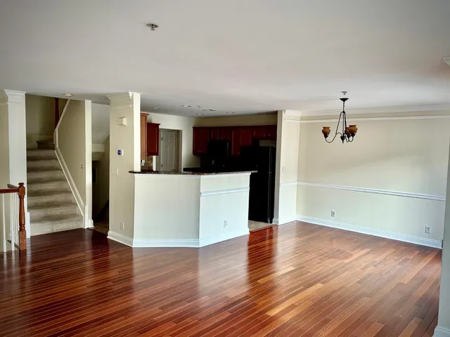 a view of a kitchen with wooden floor and electronic appliances