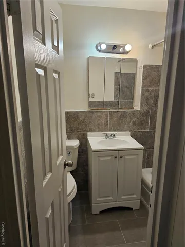 a bathroom with a sink and mirror with toilet