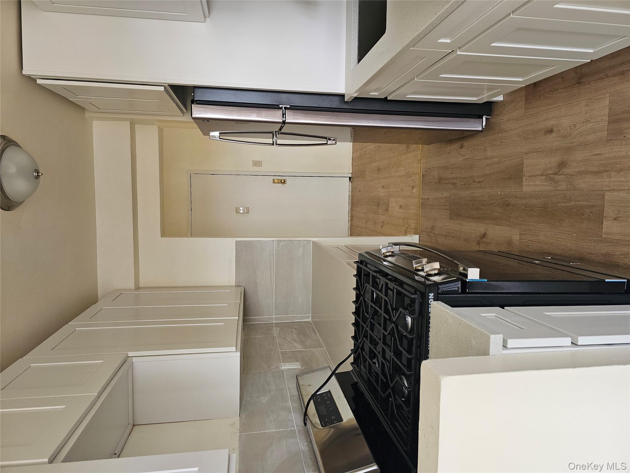 20 Wendell Street Hempstead, NY 11550 - Photo 4 of 6 a kitchen with granite countertop a refrigerator stove and white cabinets