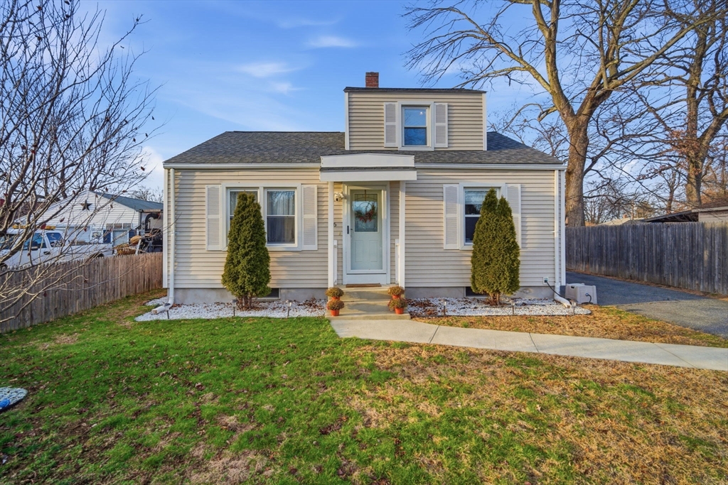 a view of a house with a yard and tree in front of it