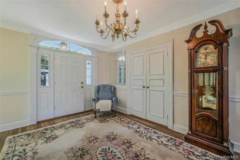 a view of a hallway with wooden floor windows and a chandelier