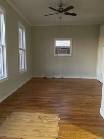 a view of a room with wooden floor and window
