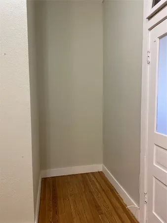 a view of a small space with wooden floor and a window