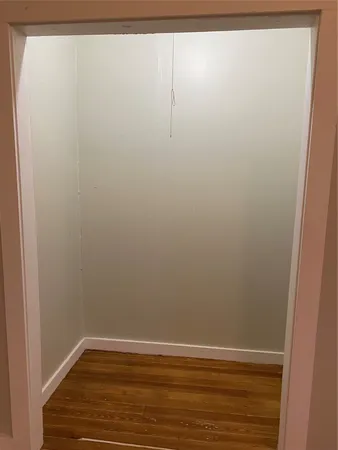 a view of a small space with wooden floor and a window