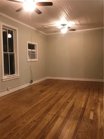a view of a room with wooden floor and window