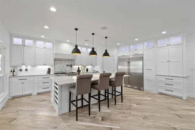 a large kitchen with kitchen island a sink table and chairs