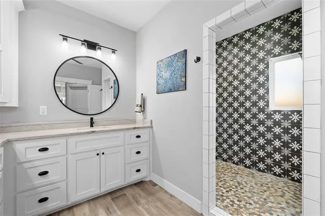 a bathroom with a sink a mirror a vanity and a shower