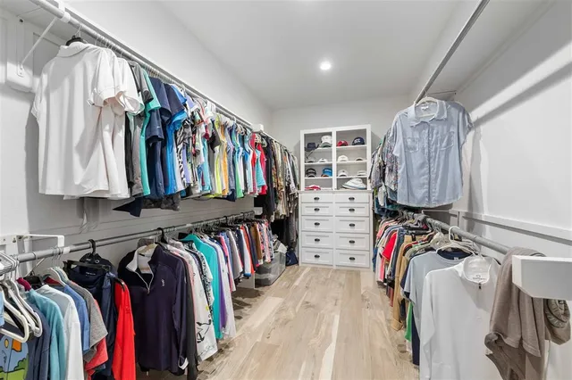 a view of walk in closet with clothes