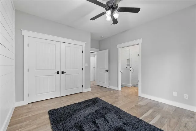 a bedroom with a bed and a chandelier fan
