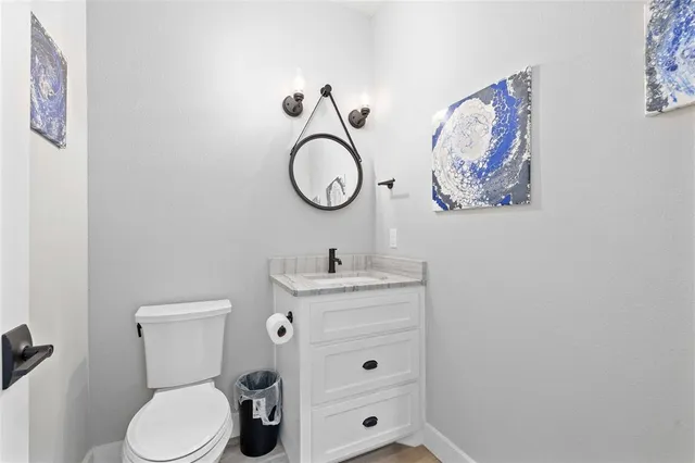 a bathroom with a toilet sink vanity and mirror