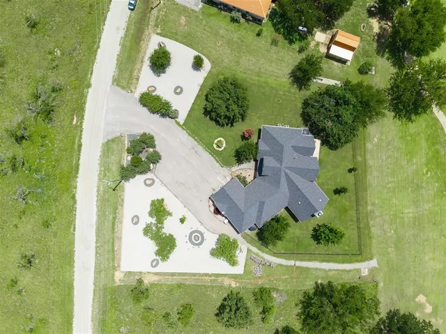 an aerial view of a house with a yard and lake view