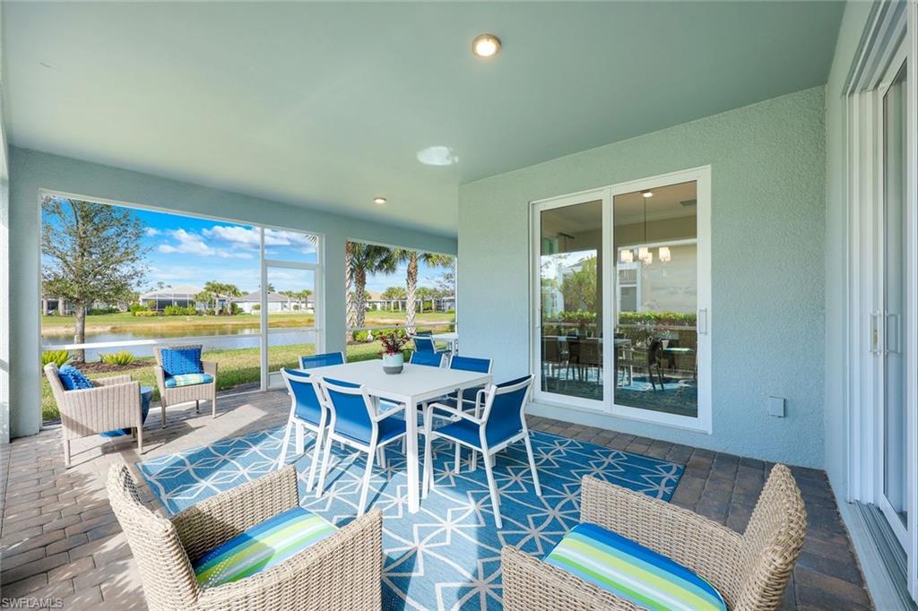 20052 Wymberly Way Estero, FL 33928 - Photo 17 of 27 a dining room with furniture a rug and a floor to ceiling window