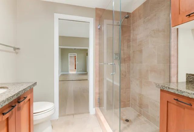 a bathroom with a granite countertop sink toilet and shower