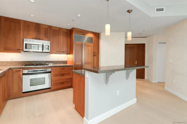 a kitchen with stainless steel appliances granite countertop a stove a sink and a refrigerator