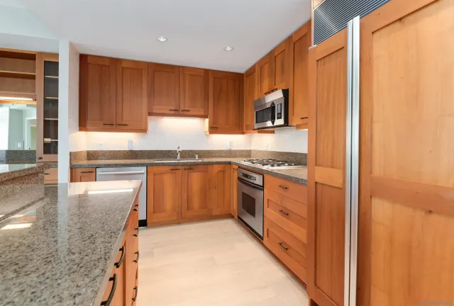 a kitchen with stainless steel appliances granite countertop a stove and a refrigerator