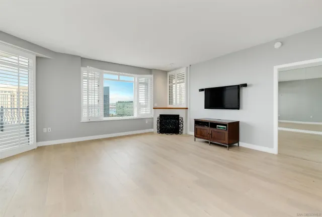 an empty room with windows and fireplace