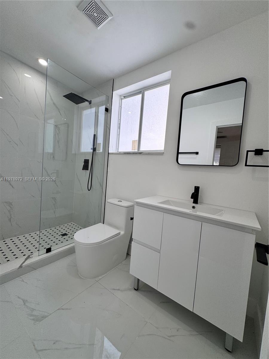 4028 Southwest 11th Street Miami, FL 33134 - Photo 11 of 17 a bathroom with a sink a toilet and mirror