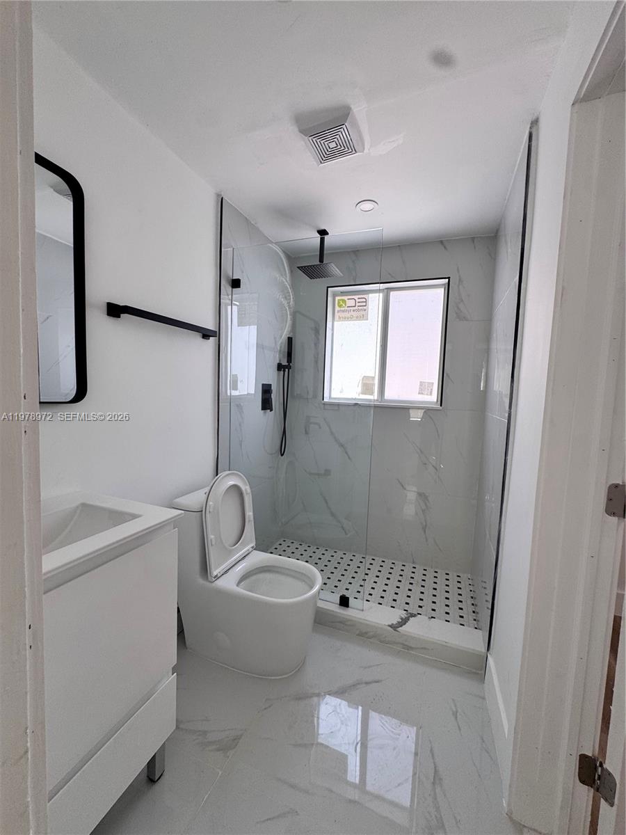 4028 Southwest 11th Street Miami, FL 33134 - Photo 12 of 17 a bathroom with a granite countertop sink toilet a mirror and shower