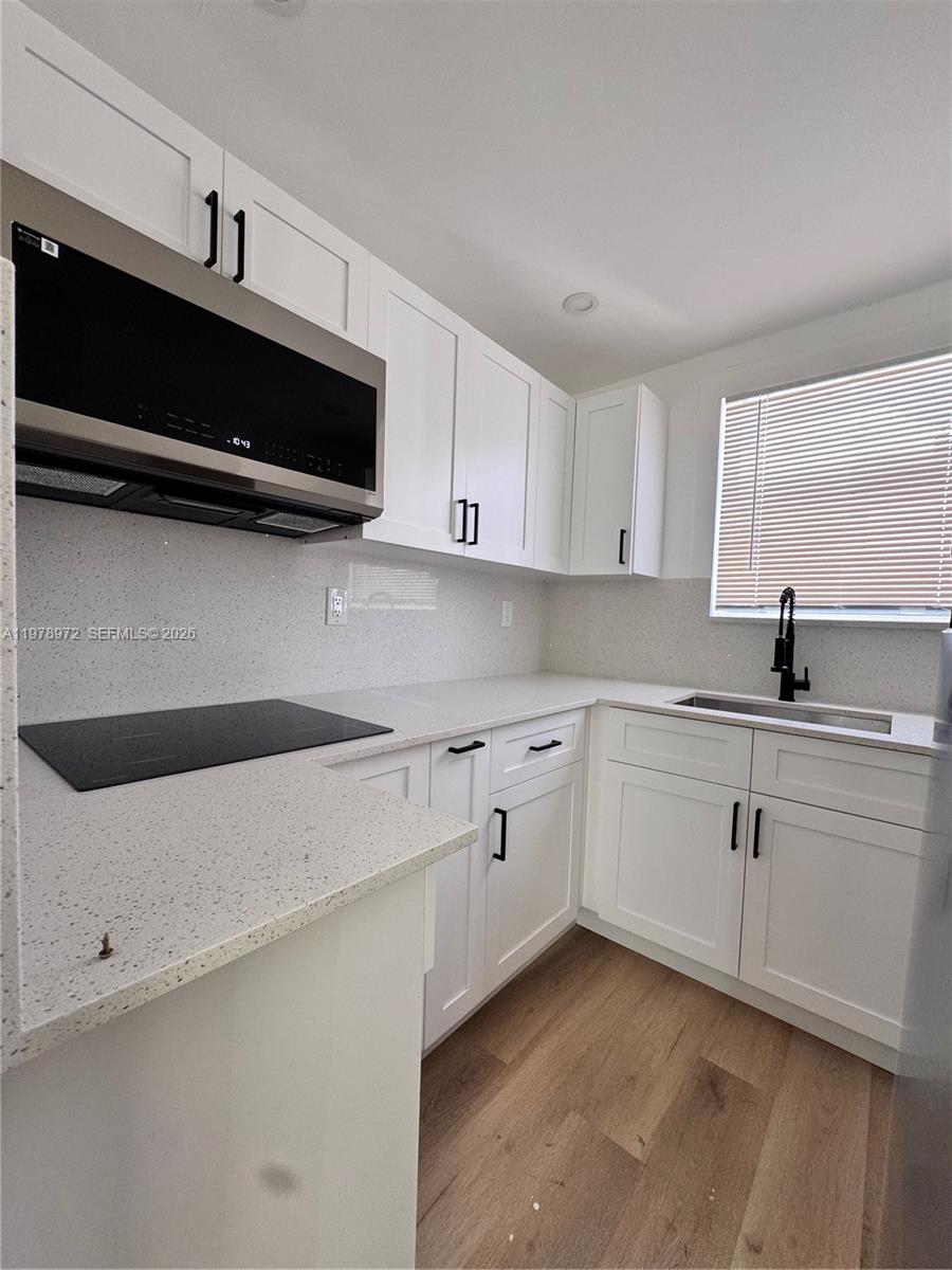 4028 Southwest 11th Street Miami, FL 33134 - Photo 6 of 17 a kitchen with stainless steel appliances white cabinets and a sink
