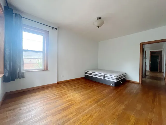 a room with a wooden floor and a window