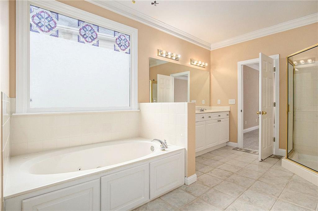 1389 Turtlebrook Lane Lawrenceville, GA 30043 - Photo 23 of 30 a bathroom with a bathtub and a shower