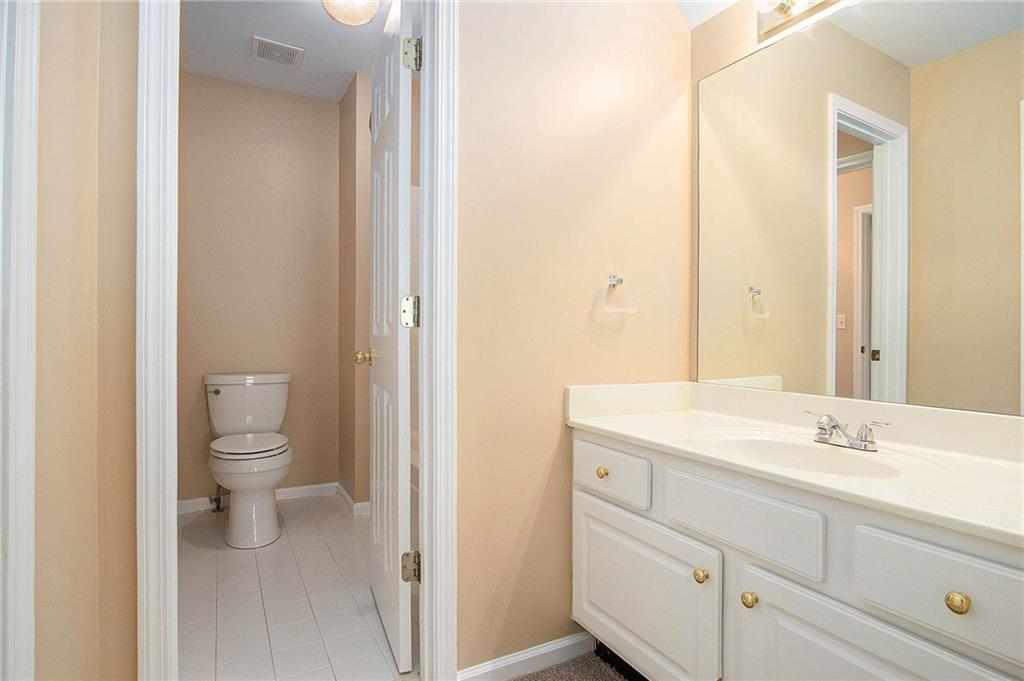 1389 Turtlebrook Lane Lawrenceville, GA 30043 - Photo 26 of 30 a bathroom with a toilet a sink and a mirror