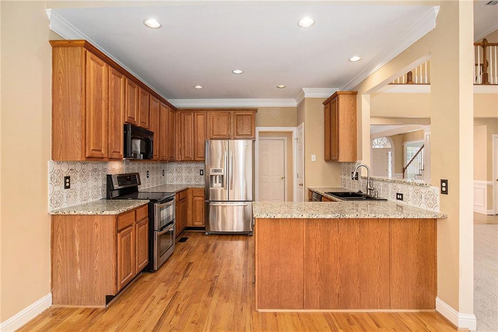 1389 Turtlebrook Lane Lawrenceville, GA 30043 - Photo 9 of 30 a large kitchen with granite countertop a large counter top space a sink stainless steel appliances and cabinets