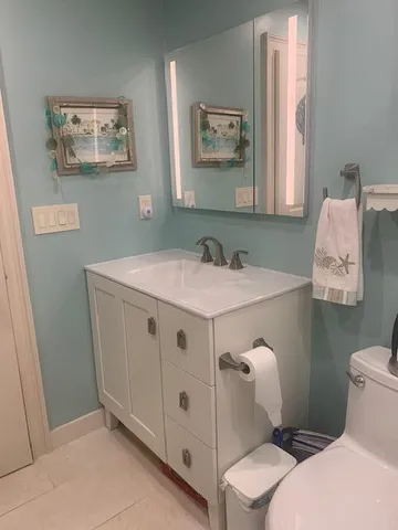 a bathroom with a sink mirror and toilet