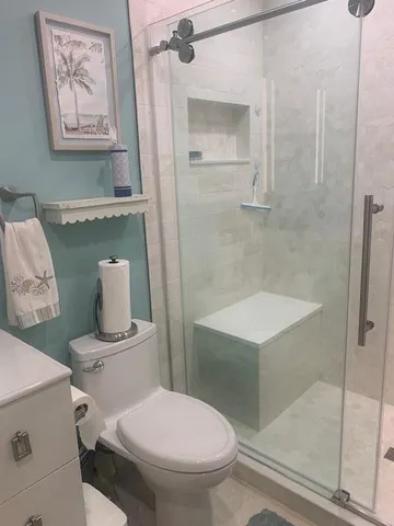 a white toilet sitting next to a bathroom sink