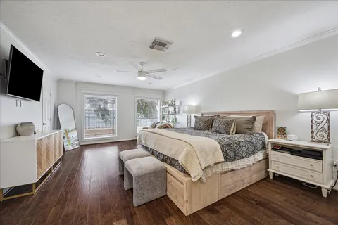 a spacious bedroom with a bed and a flat screen tv