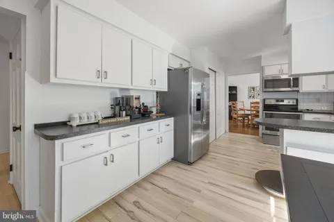 a kitchen with white cabinets and stainless steel appliances