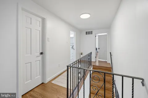 a view of a hallway with wooden floor and entryway