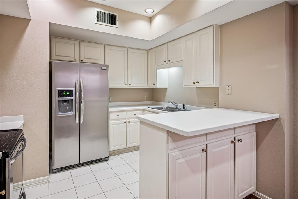 5200 Keller Springs Road, Unit 110 Dallas, TX 75248 - Photo 11 of 28 a kitchen with a refrigerator sink and cabinets