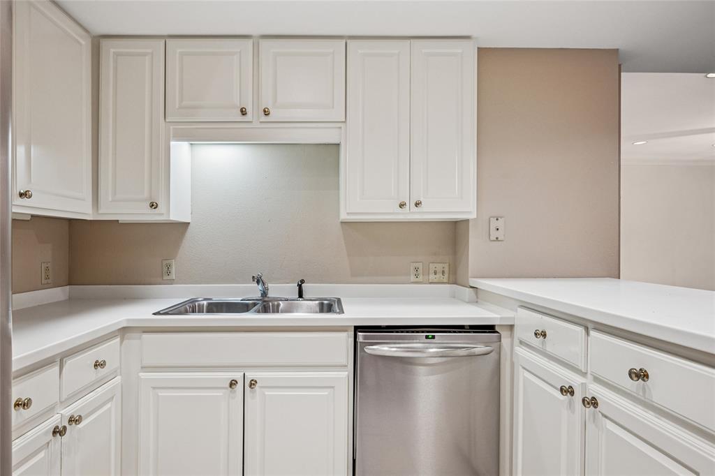 5200 Keller Springs Road, Unit 110 Dallas, TX 75248 - Photo 12 of 28 a kitchen with white cabinets and white appliances