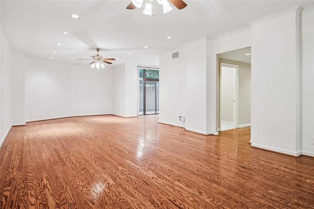 5200 Keller Springs Road, Unit 110 Dallas, TX 75248 - Photo 3 of 28 an empty room with wooden floor and chandelier fan