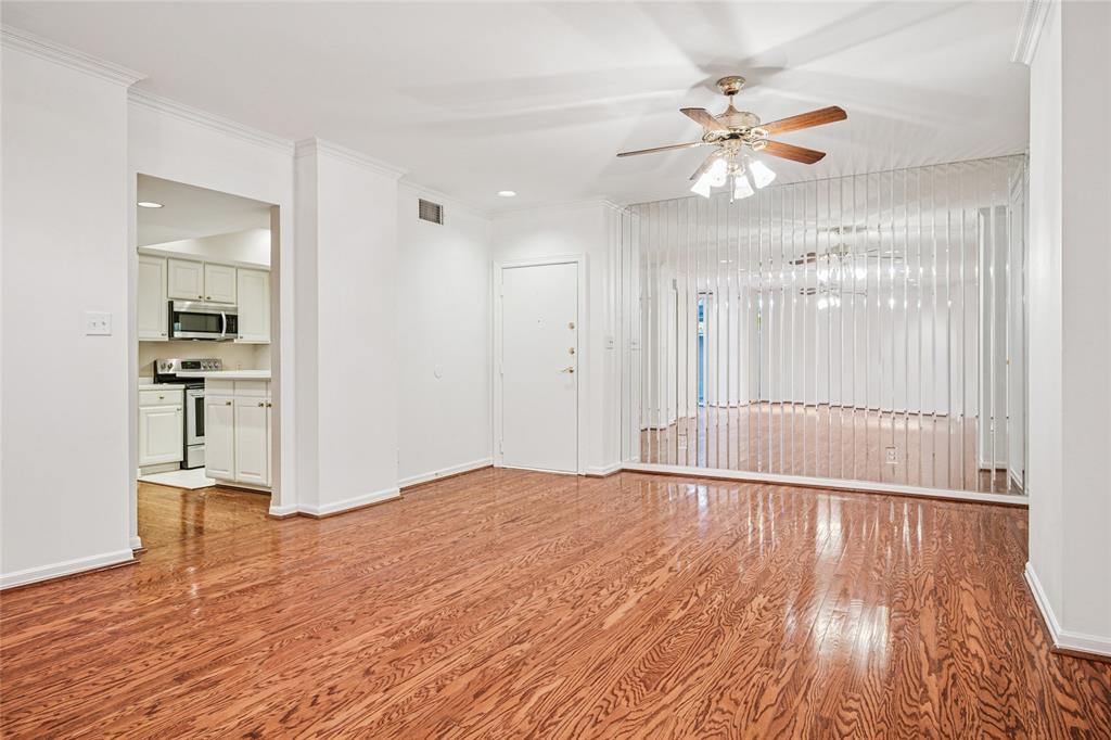 5200 Keller Springs Road, Unit 110 Dallas, TX 75248 - Photo 5 of 28 a view of empty room with wooden floor and fan